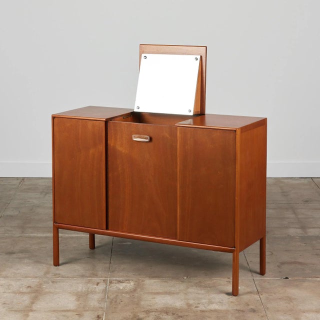 Mahogany vanity by Mount Airy Furniture, c.1960s, USA. The dresser features three sleek door fronts which open to reveal...