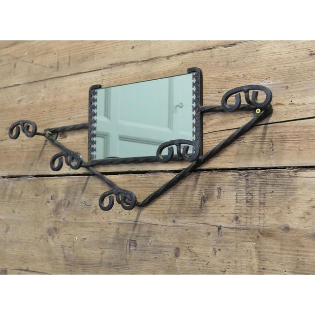 This delightful French 60s coat rack has a Triangular shape with a mirror at the centre and it has 5 curly iron double...
