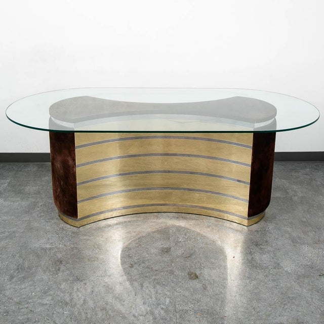 Unique 1970s Italian dining table. The oval glass top sits on a curved mirrored base with brown velvet detailing....