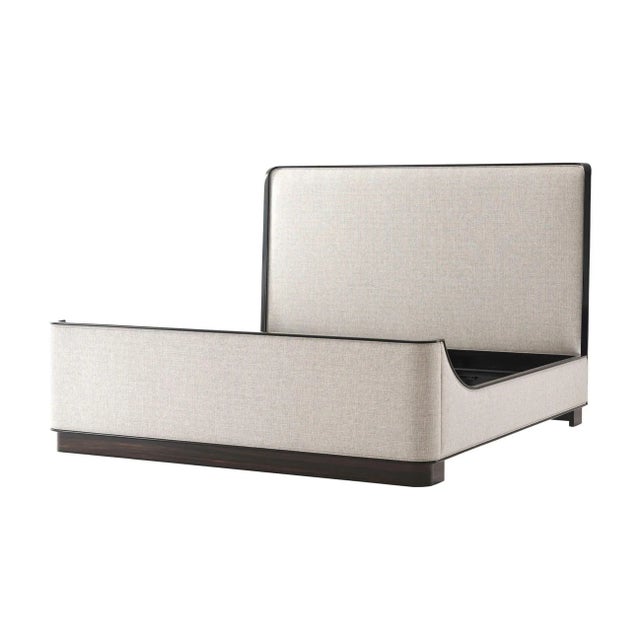 A Mid Century upholstered king size bed with a gently bowed and upholstered headboard with dark wood trim, matching rails...