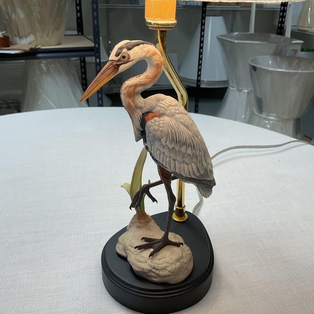 Add a touch of coastal charm and sophistication to any room with this beautiful heron table lamp. Featuring a detailed...