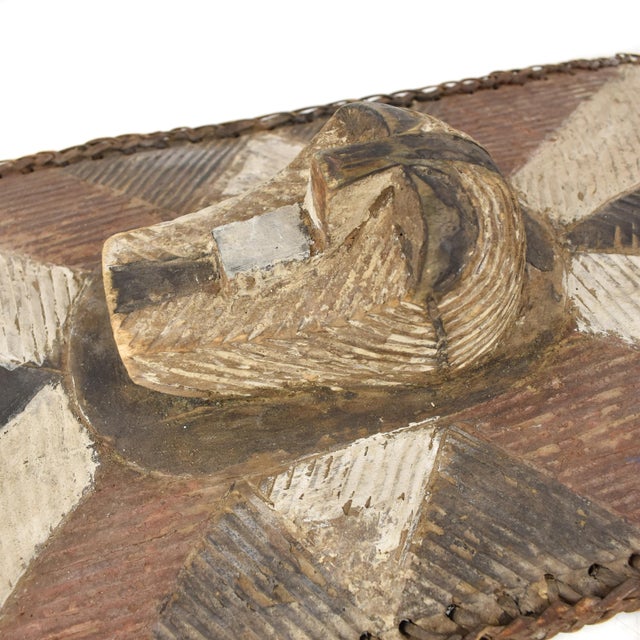 The wooden shield featuring a Kifwebe mask at its center was prevalent in the Songye region during colonial and pre-...