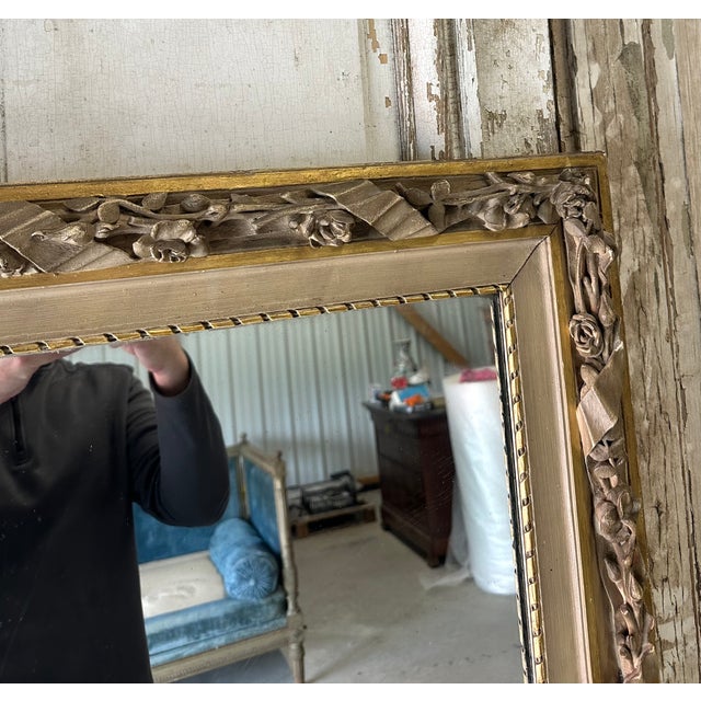 A louis xvi style fireplace mirror in repainted gray and gold wood, circa 1850. Rich wood ornamentation with ribbons and...