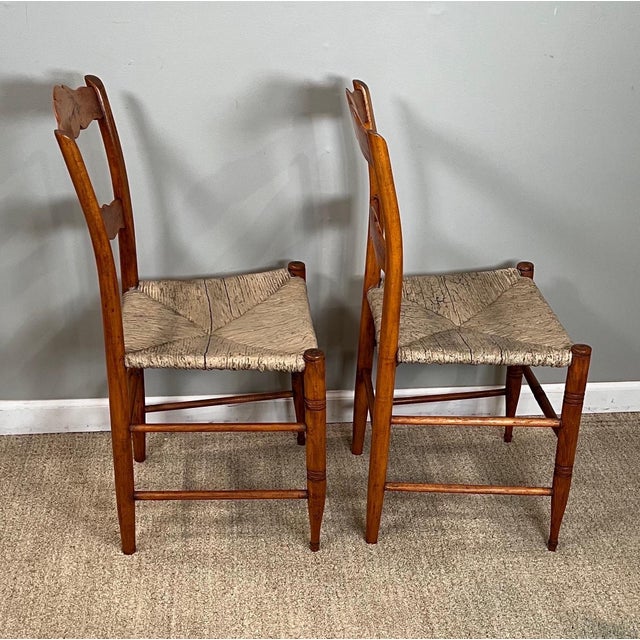 A pair of 19th century maple side chairs with rush seats. Seats with remnants of paint. Frames tightened. Chairs touched...