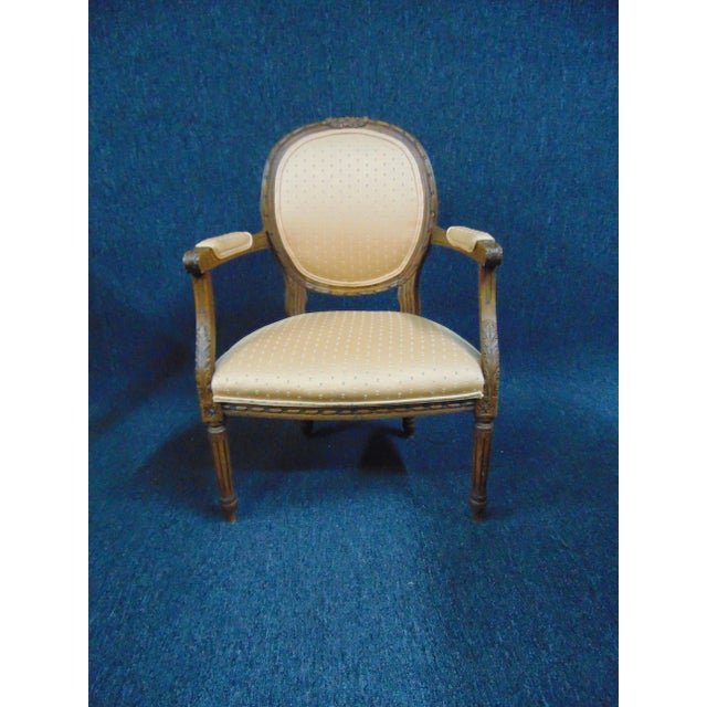 Louis XVI Style Carved Walnut Open Armchair, decorative upholstered back and seat, carved walnut frame , reeded legs.