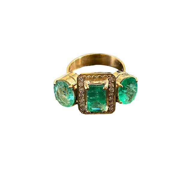 This stylish Art Deco Style 18K yellow gold emerald and diamond 3 stone ring features a 4 prong mounting with a 4.5mm...