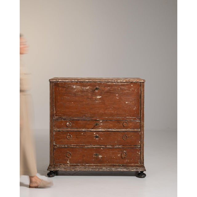This early 19th century Gustavian patinated wood secretary desk from Sweden is painted in a warm, worn terracotta red,...