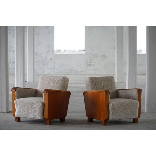 A charming pair of Art Deco lounge chairs crafted in elm and reupholstered in luxurious shearling lambswool. Made in the...