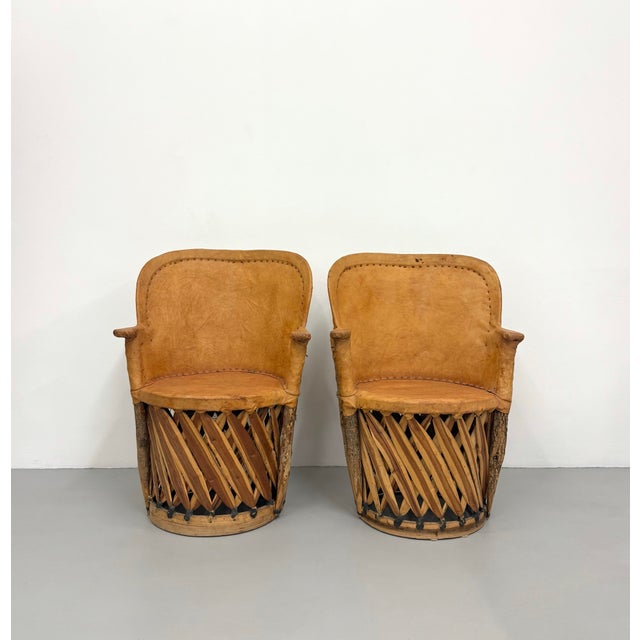 A distinctive pair of vintage Mexican armchairs handcrafted from woven wood, natural branches, and thick saddle leather...