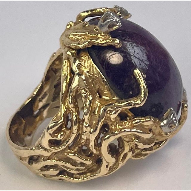 This is a 1960s statement ring featuring a large purple sapphire in an organic Brutalist-style 18K gold setting. On the...
