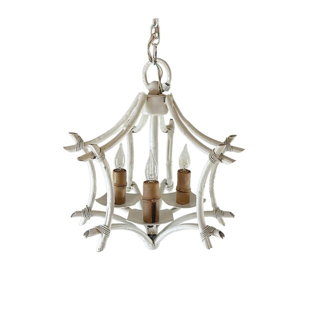 This is a vintage 1970's Faux Bamboo Tole Chandelier. This whimsical fixture has a pagoda shape with twigs of faux bois...