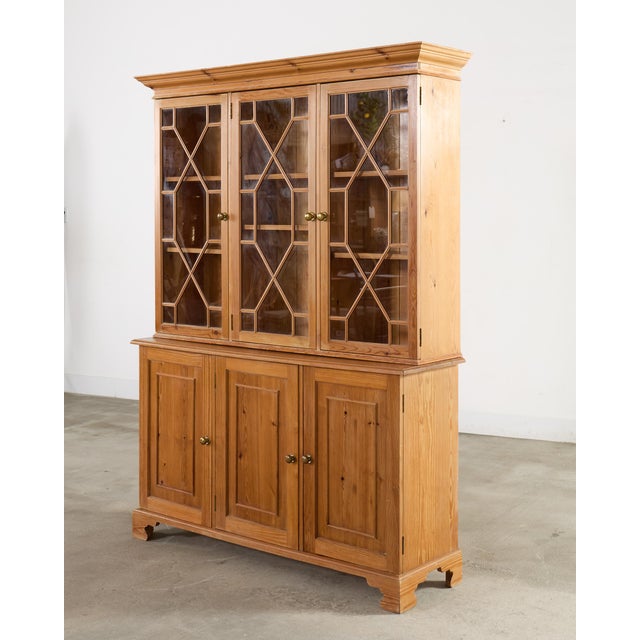 A handsome tailored 20th century large English Country George III-style bookcase cabinet or Bibliotheque finished in warm...