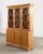 A handsome tailored 20th century large English Country George III-style bookcase cabinet or Bibliotheque finished in warm...