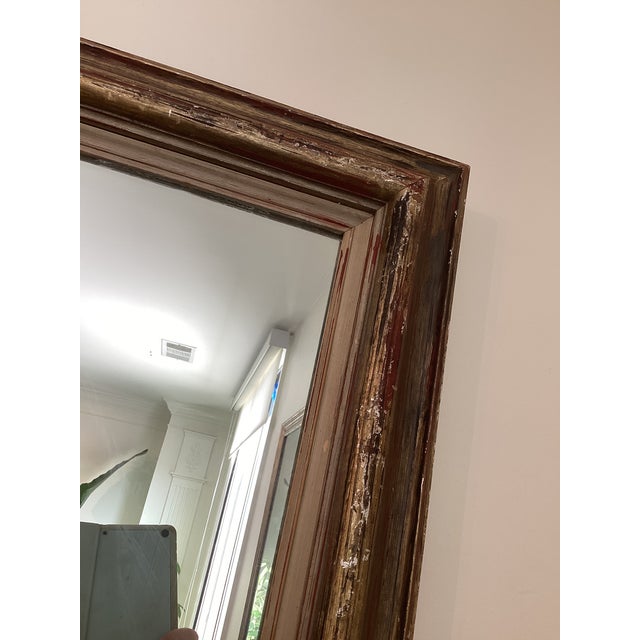 Substantial vintage framed wall mirror featuring a richly layered wood frame with a beautifully aged, distressed finish....