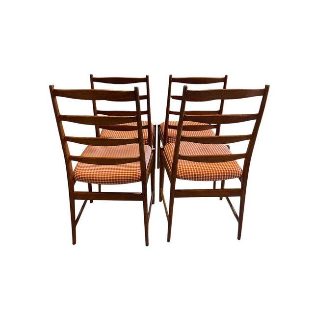 Classic Scandinavian style meets daily comfort in this set of four teak dining chairs by renowned designer Torbjørn Afdal...