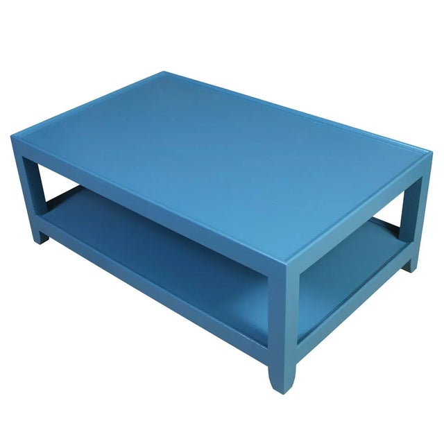 A striking two-tier coffee table, freshly painted in a vibrant blue that adds a bold pop of color to any space. The table...