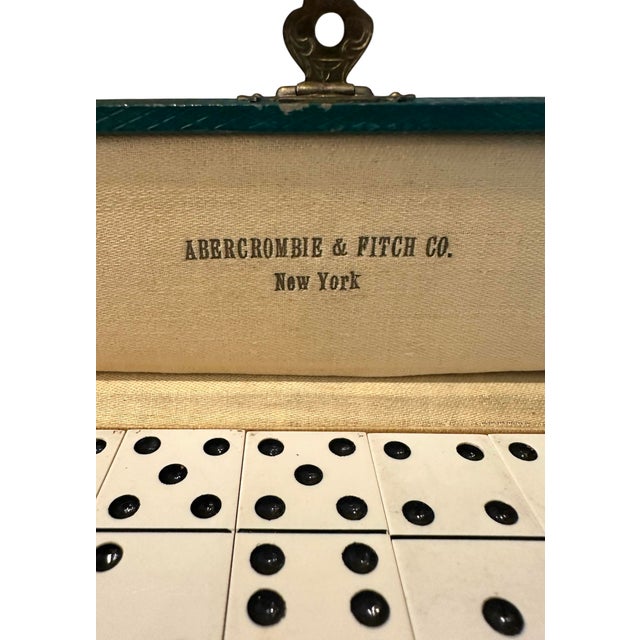 A charming, vintage, complete set of vintage dominos for Abercrombie & Fitch. Features a set of 28 faux steel gory...