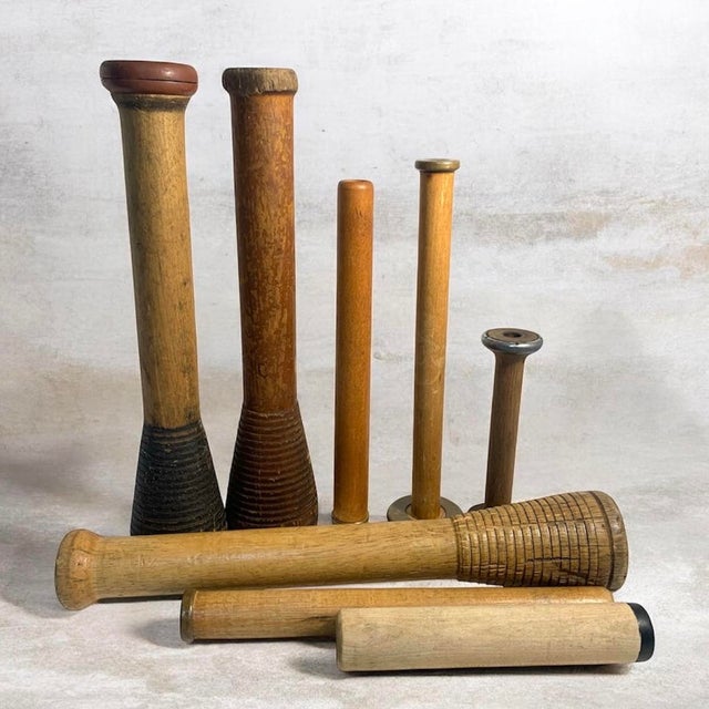 Collection of eight vintage wooden textile mill bobbins, quills, and spindles in a range of traditional industrial forms...