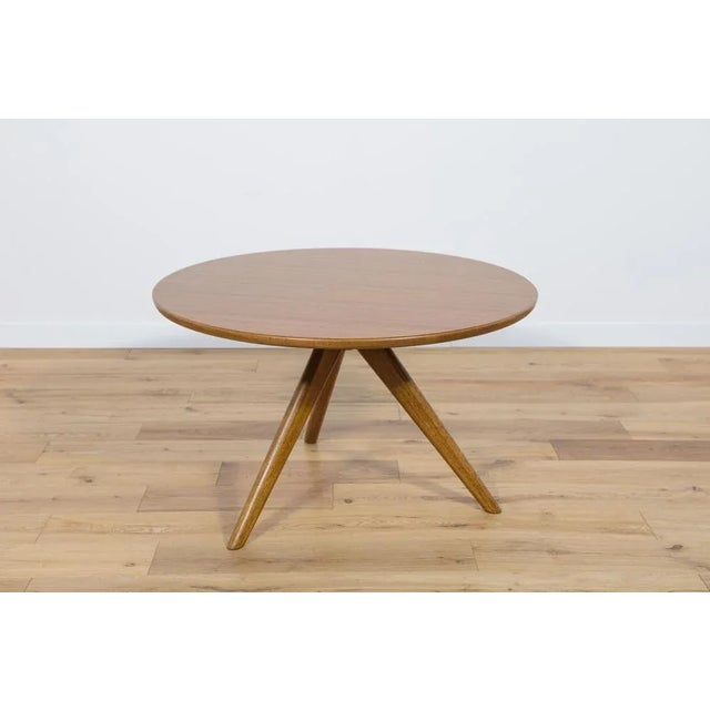 This 3-legged coffee table was produced in the 1960s by G-Plan. The pieces are made of solid beech and teak veneer....