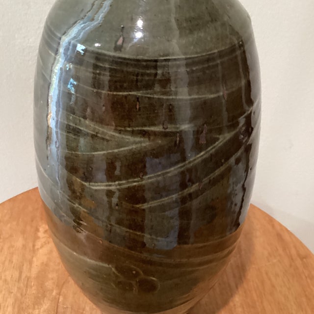 The product is a vintage stoneware vase in a unique horizontal rib bottle shape, stamped and signed by the handcrafted...