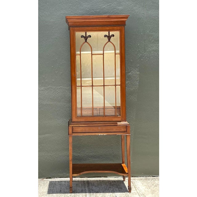 This vintage mahogany glass display cabinet is a distinguished example of early to mid-20th-century craftsmanship,...
