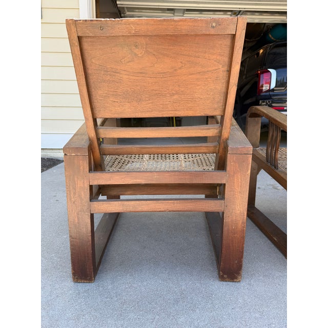 Pair of vintage Art Deco / colonial-style lounge chairs with striking architectural lines and handwoven cane seats. These...