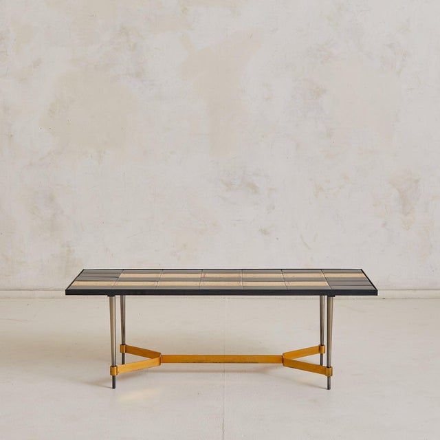 A graphic, grid-patterned coffee table from 1970s France, featuring glazed ceramic tiles arranged in bold alternating...