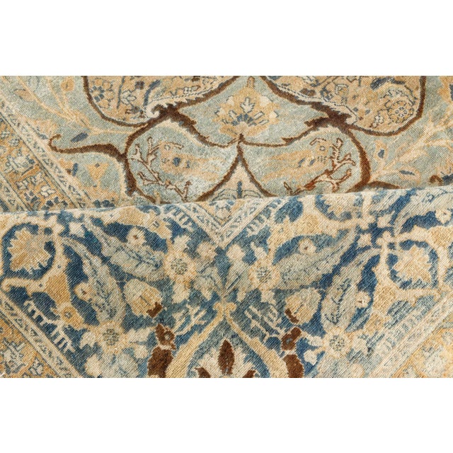 An early 20th century Tabriz Persian rug, the camel field with an overall herati pattern around a central blue medallion...