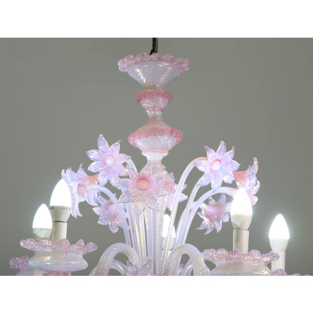 Extraordinary Murano glass chandelier adorned with pink flowers. The chandelier features 5 arms and 5 light points. It...