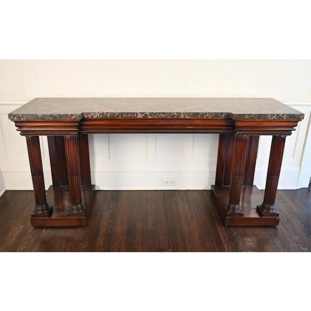 English Regency console or serving table. Brown marble top. Neoclassical stop fluted columns supporting break fronted...