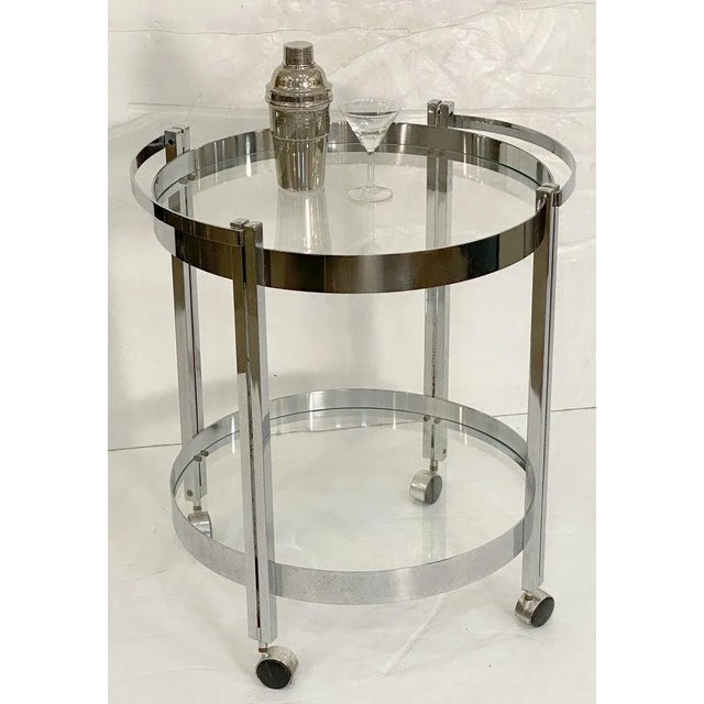 A fine French round or circular table of chromed steel with two concentric circle tiers of inset glass, set upon rolling...