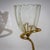 Small table lamp featuring a gracefully twisted brass base and a petite flower-shaped glass shade. The hand-blown glass...