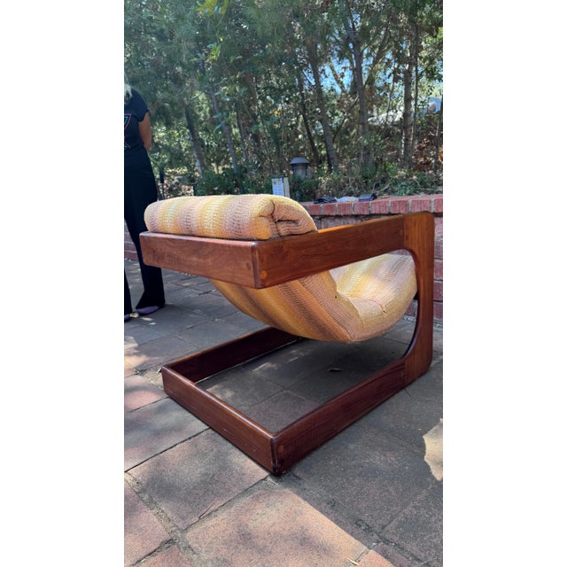 Thick walnut side frames with rounded corners. Cantilever/sled base shape. Exposed dowels or plug details. Stamp for...