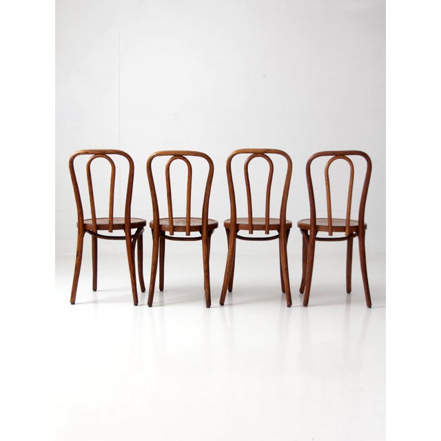 Elegant set of four vintage 1930s bentwood dining chairs by the Great Northern Chair Company. Each chair features a...