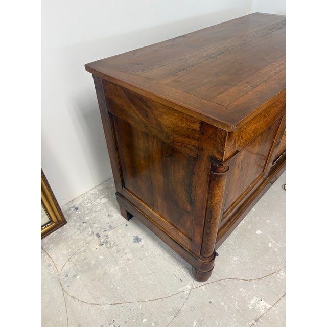 This early 19th century French sideboard is crafted from richly toned walnut, prized for its warm color and beautifully...