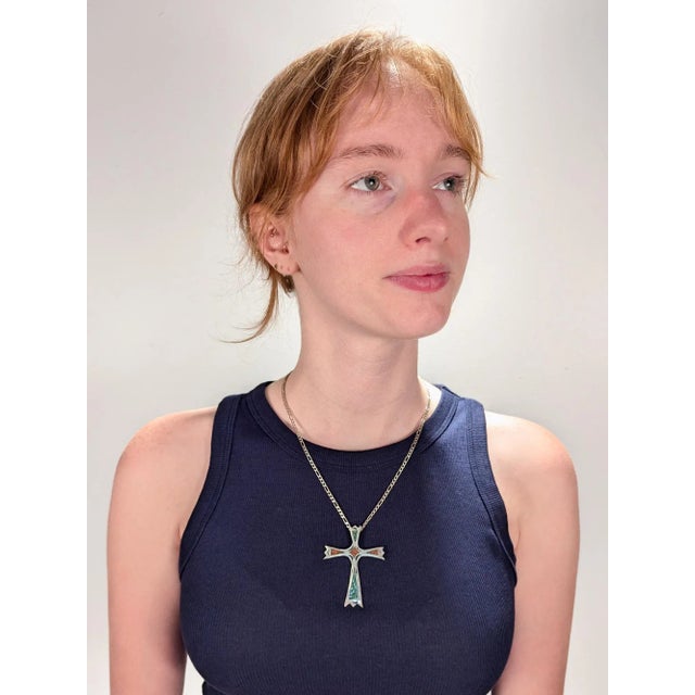 A fine Southwestern pendant cross. In silver. With chip turquoise and coral inlay and hammered decoration throughout. With...
