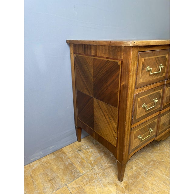A Louis XVI style commode with a central projection, crafted from solid walnut and walnut veneer, as well as native wood....