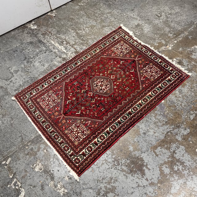 Design Plus Gallery presents a 3ft 7in × 5ft 4in Vintage Persian Area Rug from Iran. The rug has a red field with a...
