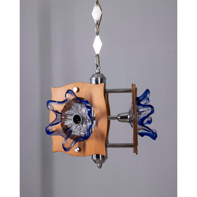 Chandelier with chromed metal and wood structure, Murano glass lampshades with blue details, Italian design, 1960s. Up to...