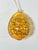 Vintage blown glass egg ornament in a rich, translucent amber color, decorated with an intricate pattern of overlapping...