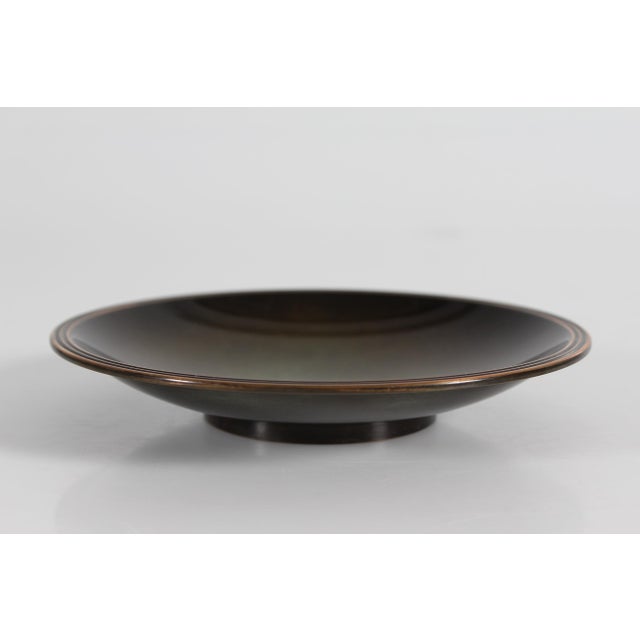 Small decorative Art Deco low bowl made of bronze. The brown patina mixes in with cobber green towards the center of the...