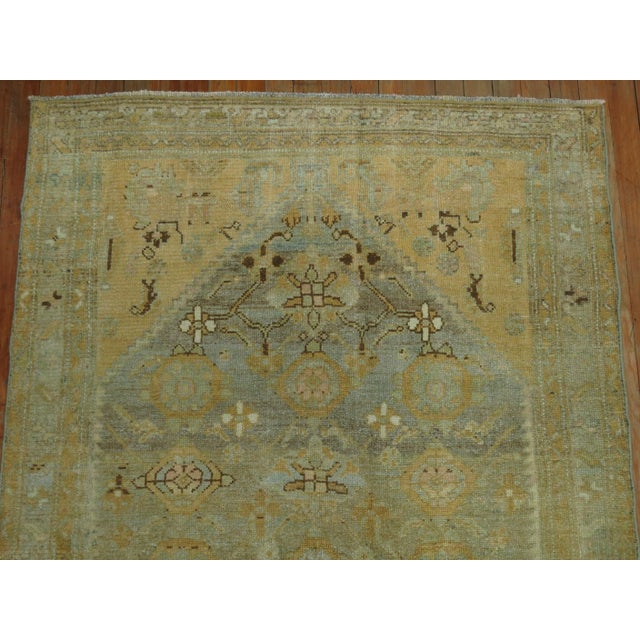 A throw size 20th century Persian Malayer rug with an all-over sun-faded mini-khani design in sand and light blue...