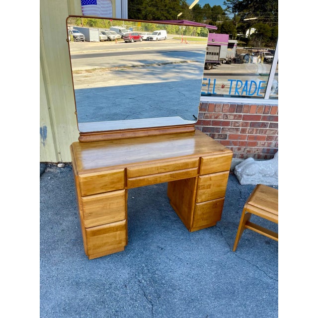 Vintage solid wood vanity dresser and stool designed by mid-century modern designer Russel Wright dating to the 1940s....