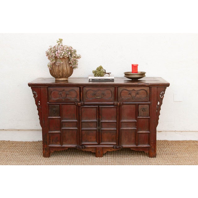 Scrolling openwork brackets — carved in a form collectors call "butterfly" spandrels — fill the corners where the top...