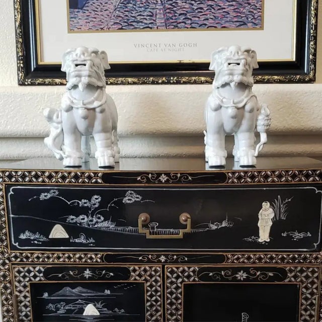 A commanding and mirrored pair of vintage 20th-century Dehua-style porcelain Guardian Lions. These "Blanc de Chine"...