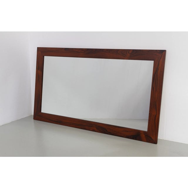 Large and impressive vintage Rosewood/palisander mirror made in Denmark in the 1960s. Nice and wide frame in rosewood...