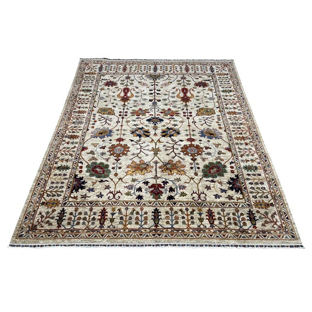 This Sultani wool area rug features a warm beige field with a Persian-style botanical design. Flowing vines, flowers, and...