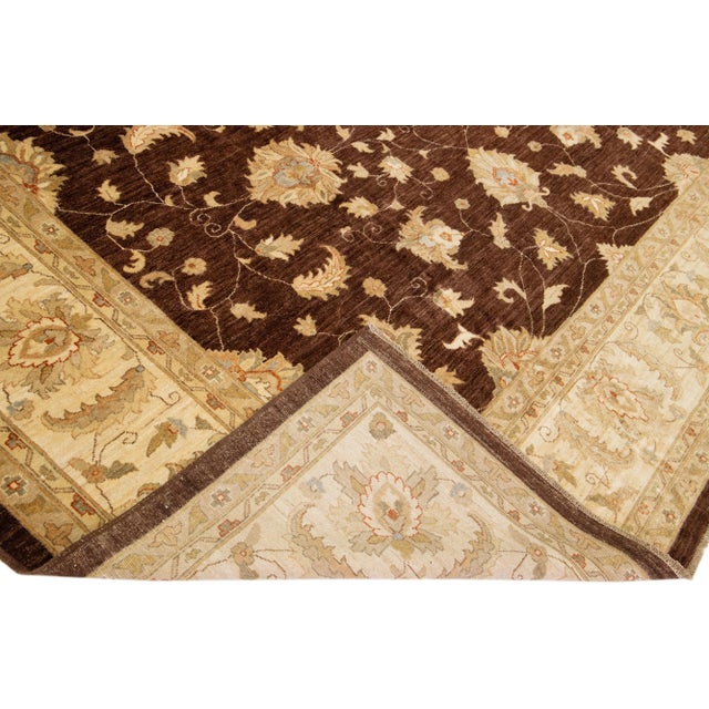Beautiful Paki Peshawar hand-knotted wool rug with a brown color field. This modern rug has a beige and golden frame with...