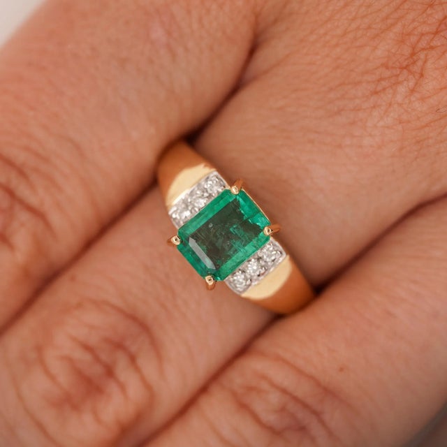 This bold cocktail ring features a 1.60 carat emerald in a classic four-prong setting with six accent diamonds on each...