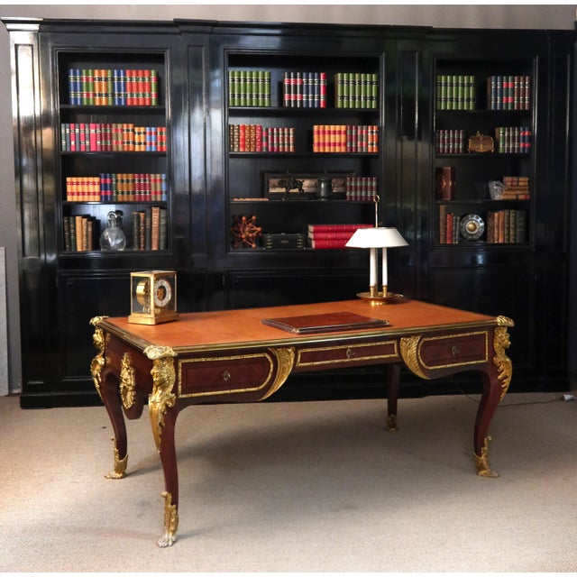 Large Louis XV style marquetry desk from the early 20th century. The top is edged with a gilt bronze molding with floral...